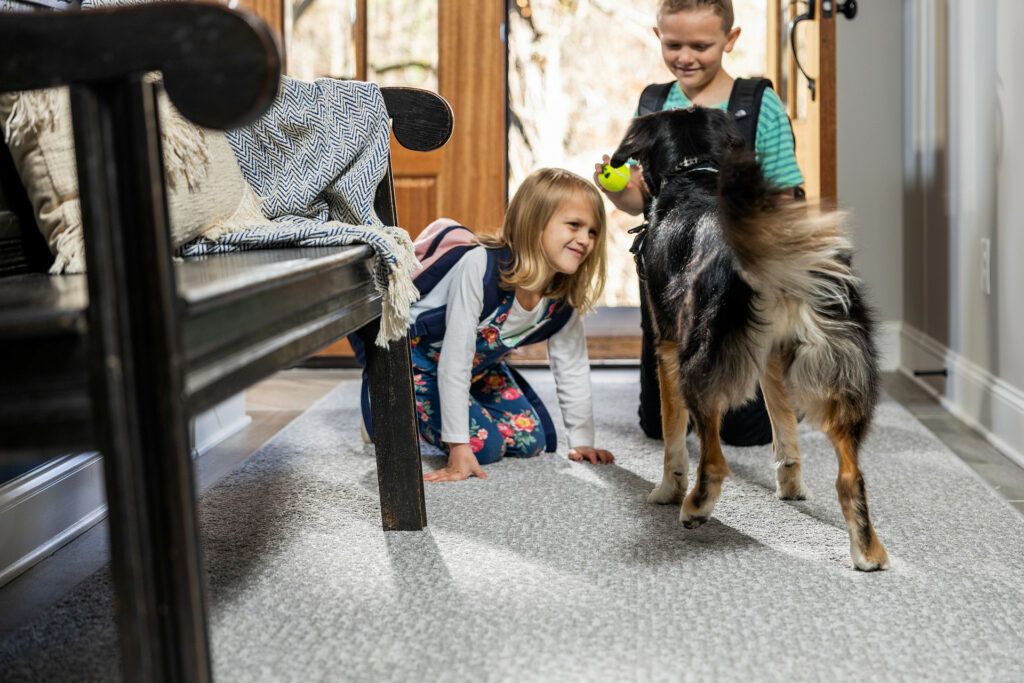 Kids playing with dog on carpet floor | Terry's Floor Fashions